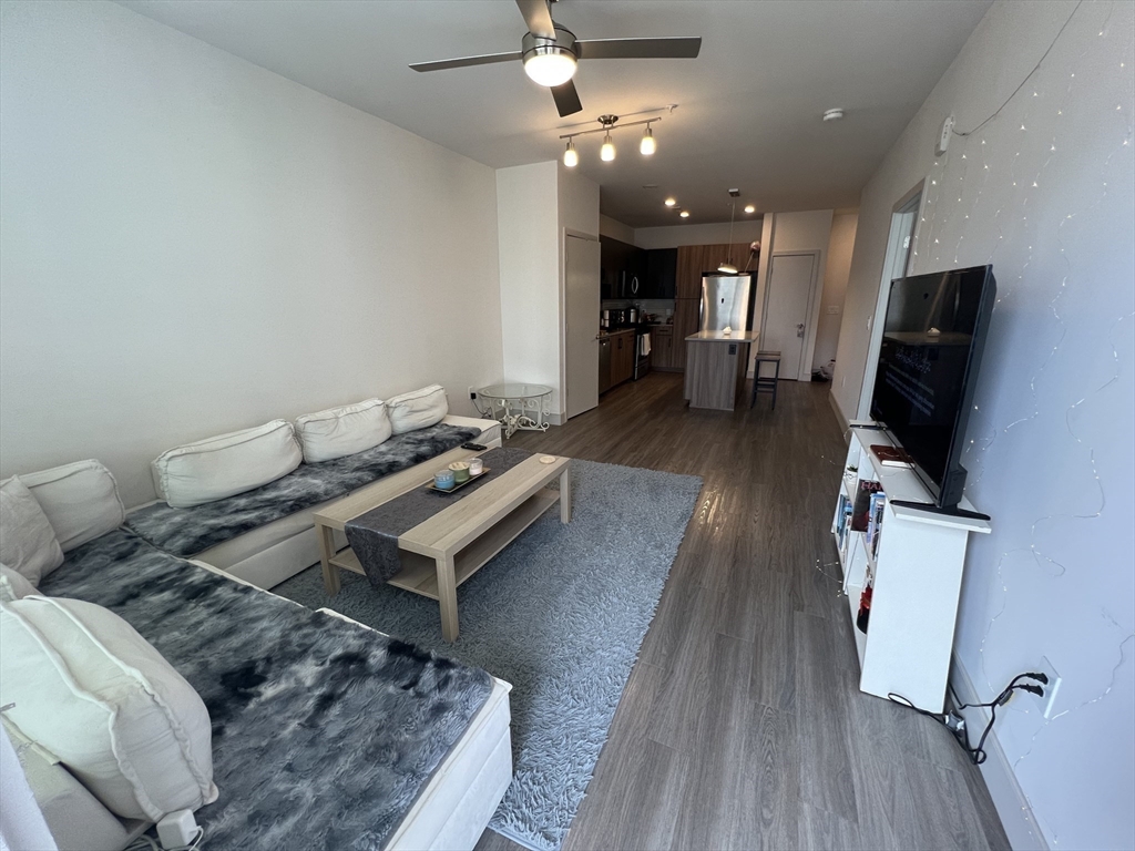 255 Vale Street, Unit 5218 Chelsea, MA 02150 - Photo 7 of 9 a living room with furniture and a flat screen tv