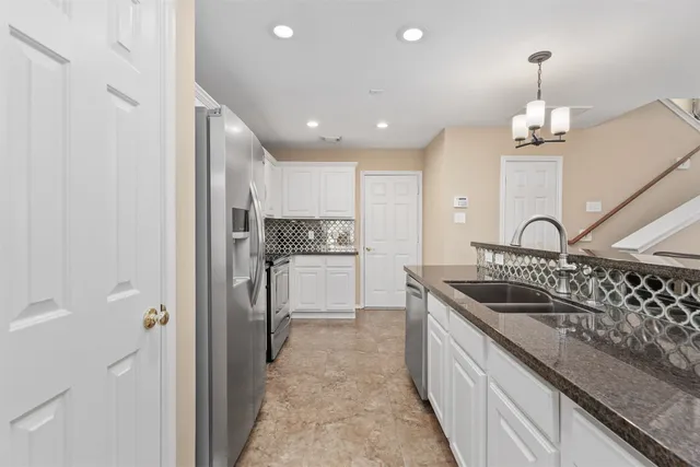 a kitchen with refrigerator sink and cabinets
