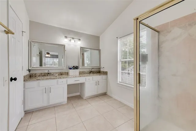 a bathroom with a granite countertop sink a mirror and a bathtub