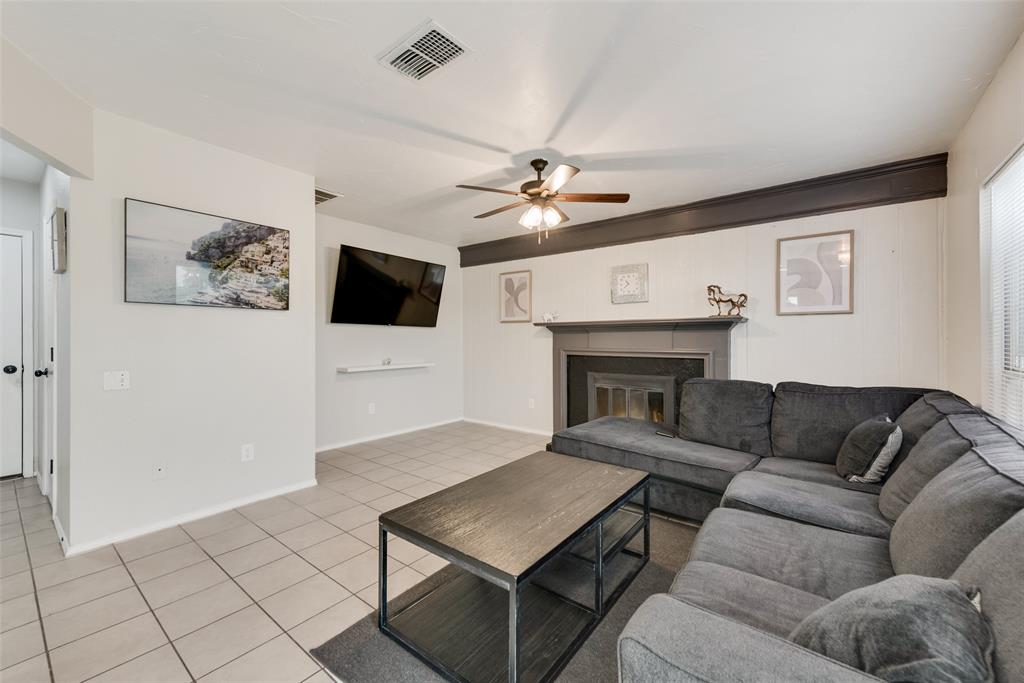 2629 Coldstream Drive Fort Worth, TX 76123 - Photo 6 of 24 a living room with furniture a flat screen tv and a wall painting