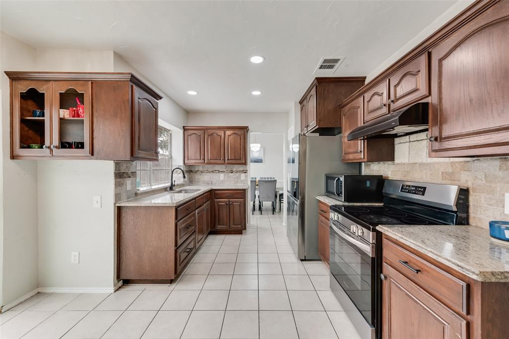 2629 Coldstream Drive Fort Worth, TX 76123 - Photo 8 of 24 a kitchen with stainless steel appliances granite countertop a stove a sink and a microwave