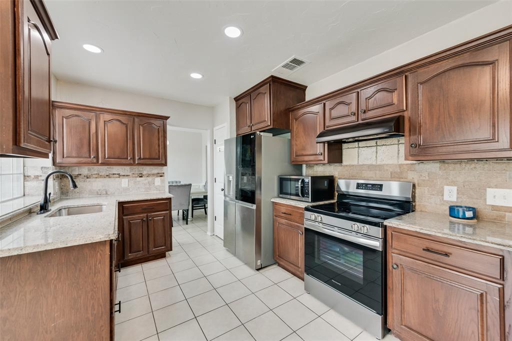 2629 Coldstream Drive Fort Worth, TX 76123 - Photo 9 of 24 a kitchen with stainless steel appliances granite countertop a stove sink microwave and cabinets