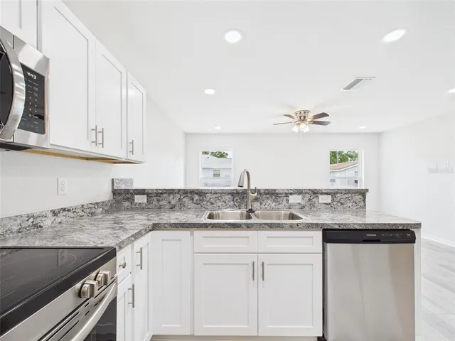 a kitchen with stainless steel appliances granite countertop a refrigerator and a sink