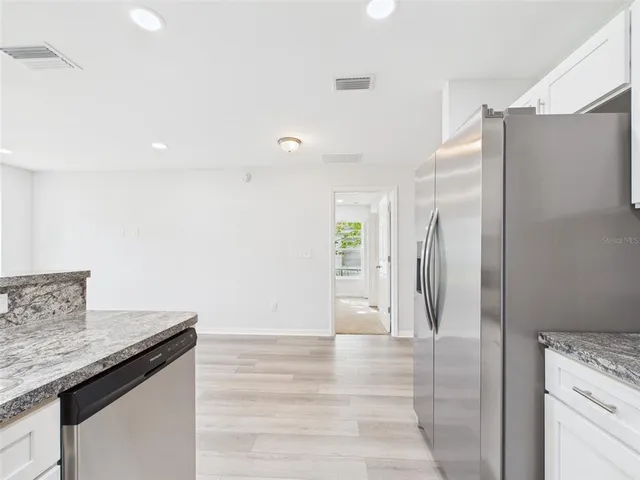 a kitchen with stainless steel appliances a refrigerator and cabinets