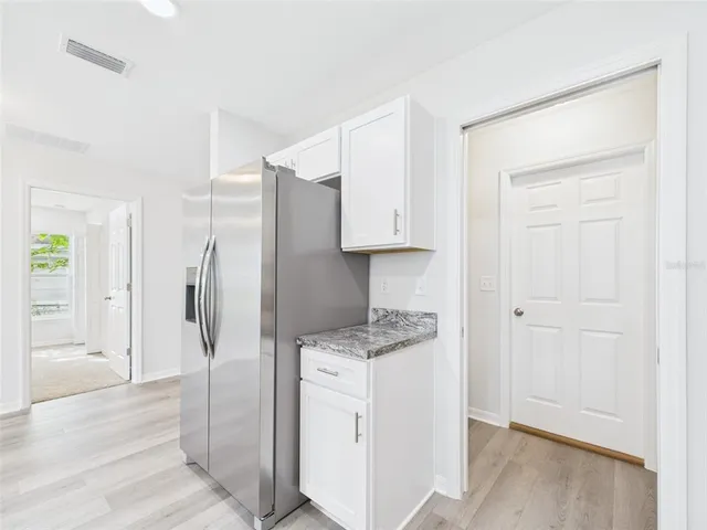 a view of empty room with window and wooden floor