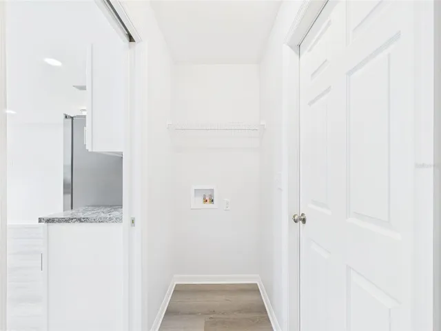 a view of a hallway with wooden floor