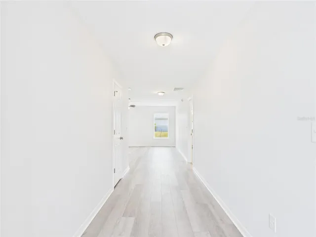 a view of a hallway with wooden floor and closet