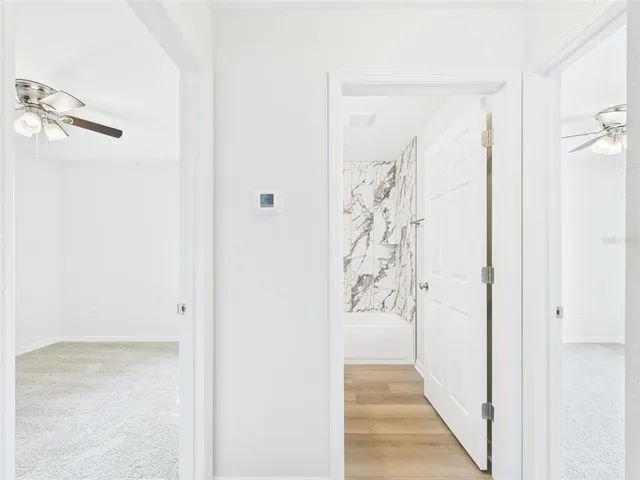 an empty room with a ceiling fan and a window