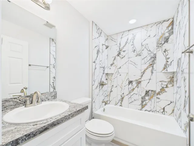 an empty room with windows and ceiling fan view