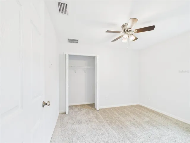 a view of a hallway with a chandelier fan and windows