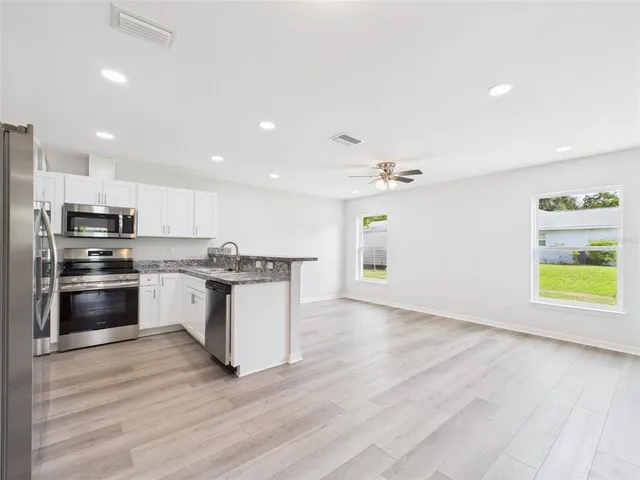 a kitchen with granite countertop a stove and a refrigerator