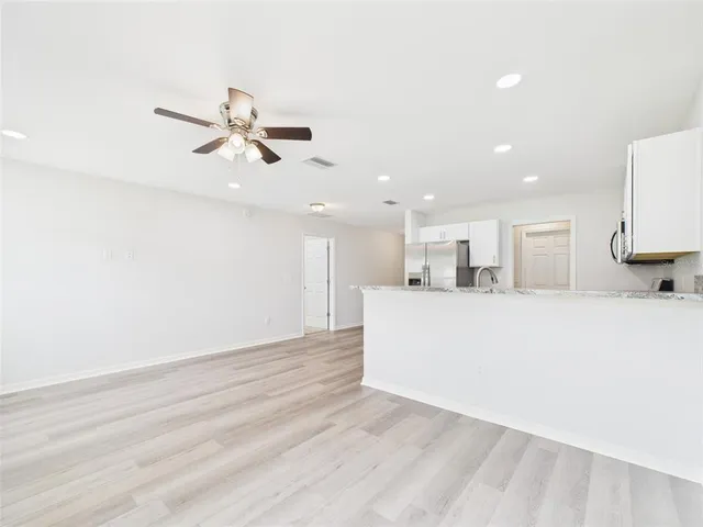 a view of kitchen with microwave and white cabinets