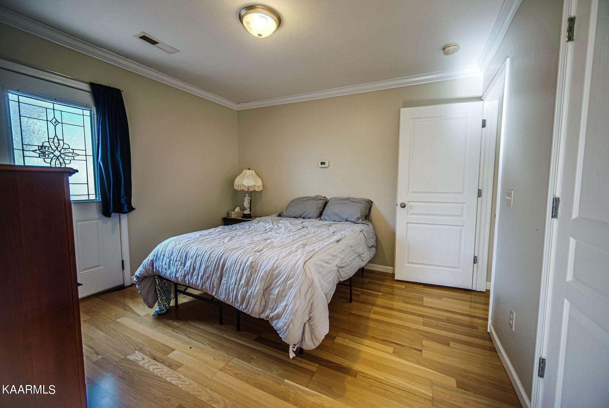 469 E Cove Monterey, TN 38574 - Photo 22 of 34 a spacious bedroom with a bed and wooden floor