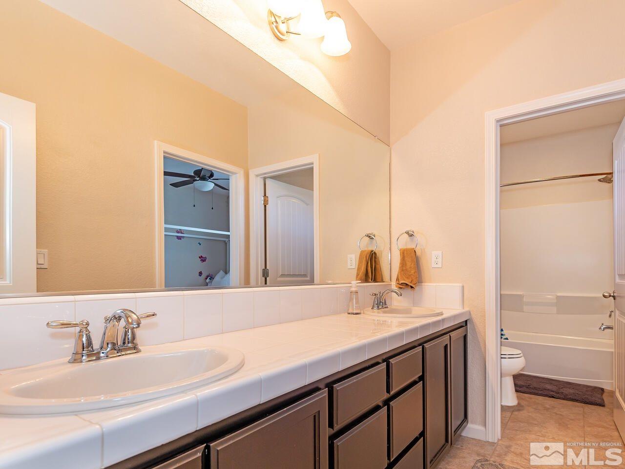 1985 Hope Valley Drive Reno, NV 89521 - Photo 17 of 19 a bathroom with a granite countertop sink and a mirror