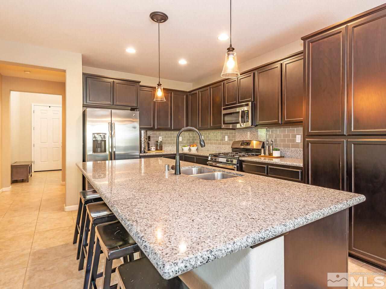 1985 Hope Valley Drive Reno, NV 89521 - Photo 6 of 19 a kitchen with stainless steel appliances granite countertop a sink refrigerator and microwave