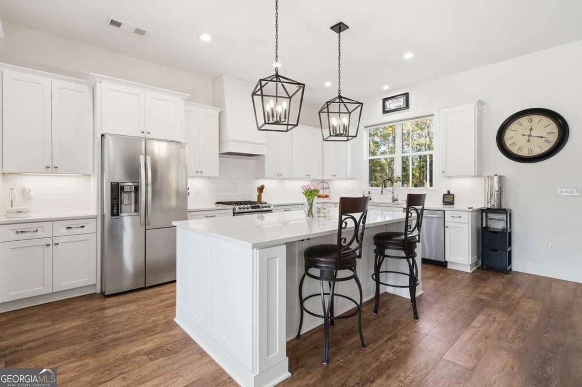 1950 Damascus Road Ball Ground, GA 30107 - Photo 9 of 29 a kitchen with stainless steel appliances a table chairs refrigerator and cabinets