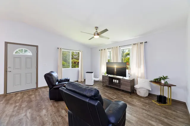 a living room with furniture a window and a flat screen tv