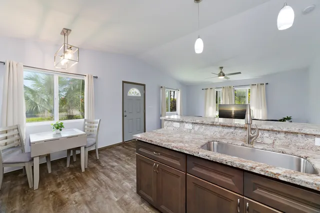 a kitchen with granite countertop sink and window