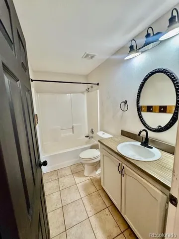 a bathroom with a granite countertop sink mirror vanity and toilet