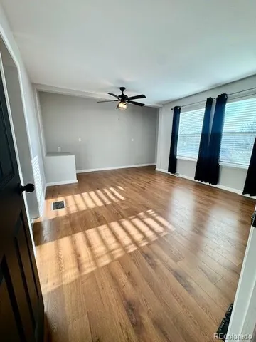 wooden floor in an empty room with a window
