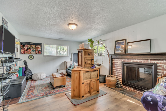 7470 Ramanee Drive Midvale, UT 84047 - Photo 23 of 29 Flex space can be a large bedroom with walk in closet or as a family room, a textured ceiling, and a brick fireplace