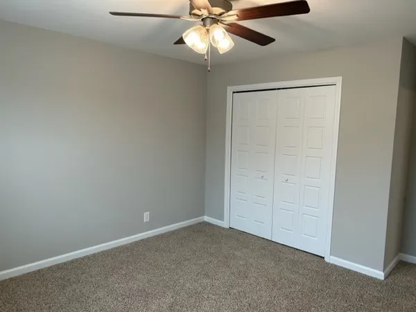 an empty room with a fan and a fan