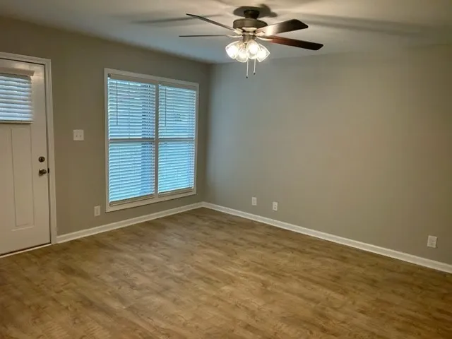 an empty room with windows and fan