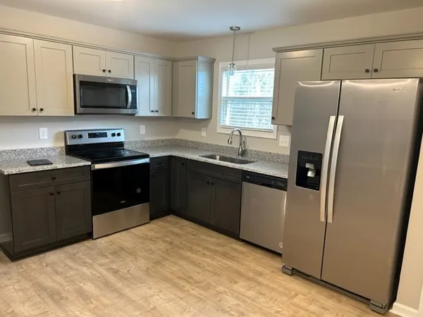 a kitchen with stainless steel appliances granite countertop a refrigerator stove a sink and a microwave