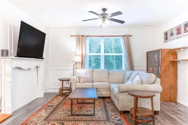 a living room with furniture a flat screen tv and a large window