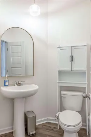 a bathroom with a toilet a sink and mirror