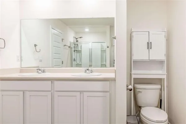 a bathroom with a sink a toilet and a mirror