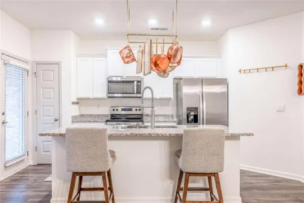 a kitchen with stainless steel appliances granite countertop a sink and a refrigerator