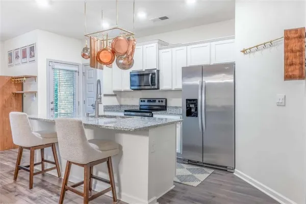 a kitchen with stainless steel appliances granite countertop a sink and a refrigerator