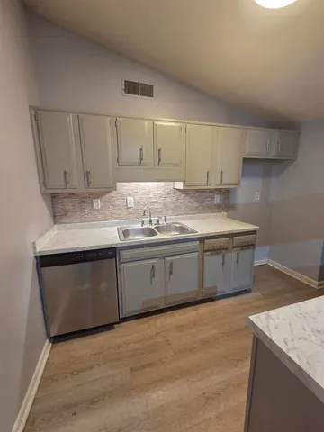 a kitchen with granite countertop a sink a stove and cabinets