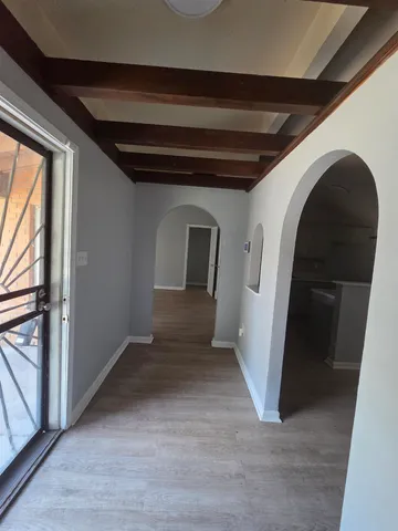a view of a hallway with wooden floor and entryway