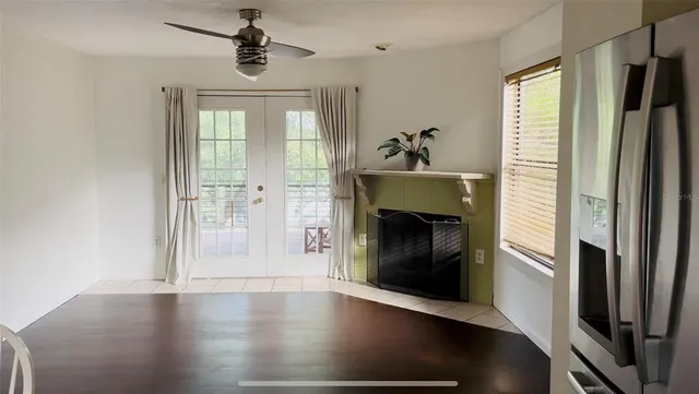 an empty room with wooden floor fireplace and windows