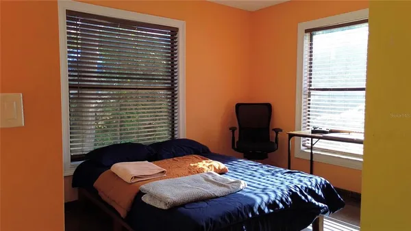 a bedroom with a bed and a chair