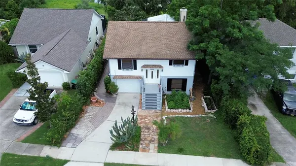 an aerial view of a house with a yard and potted plants
