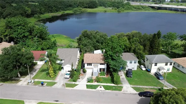 an aerial view of a house with a yard and lake view