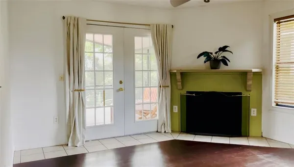 a view of an empty room with window and wooden floor