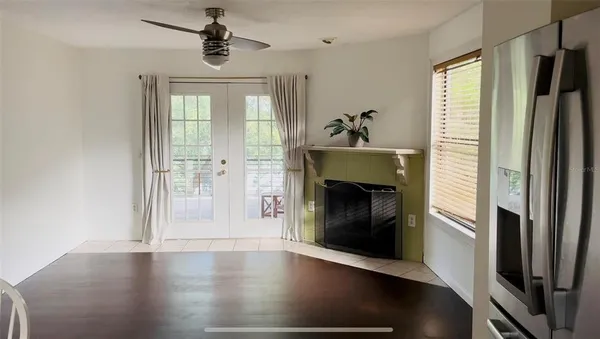an empty room with wooden floor fireplace and windows
