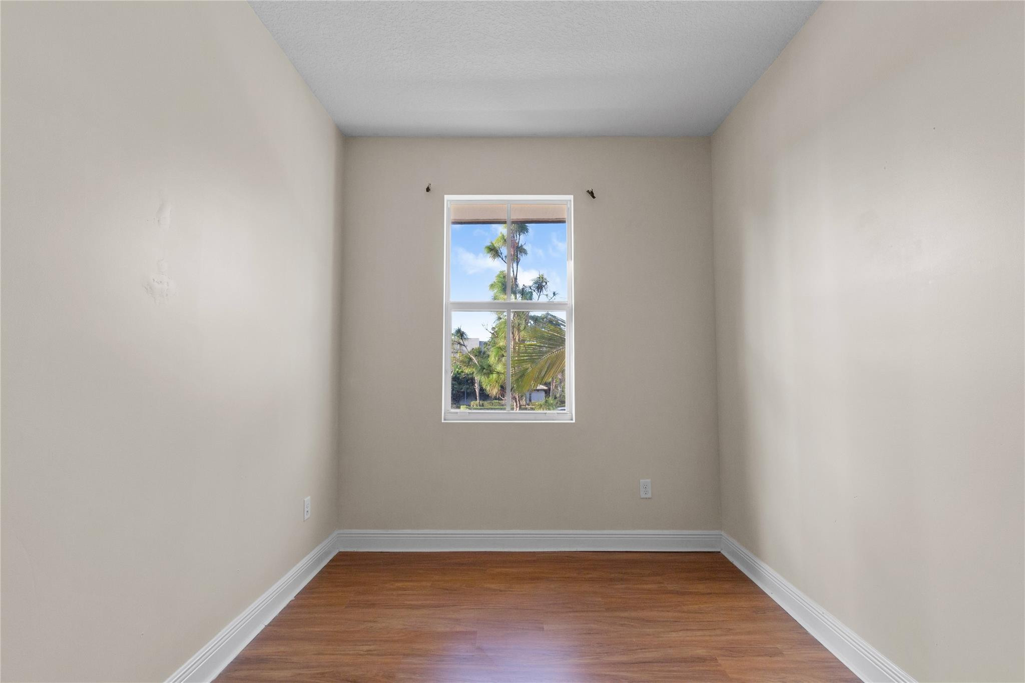 6918 Long Pine Circle Coconut Creek, FL 33073 - Photo 11 of 19 a view of an empty room with wooden floor and a window