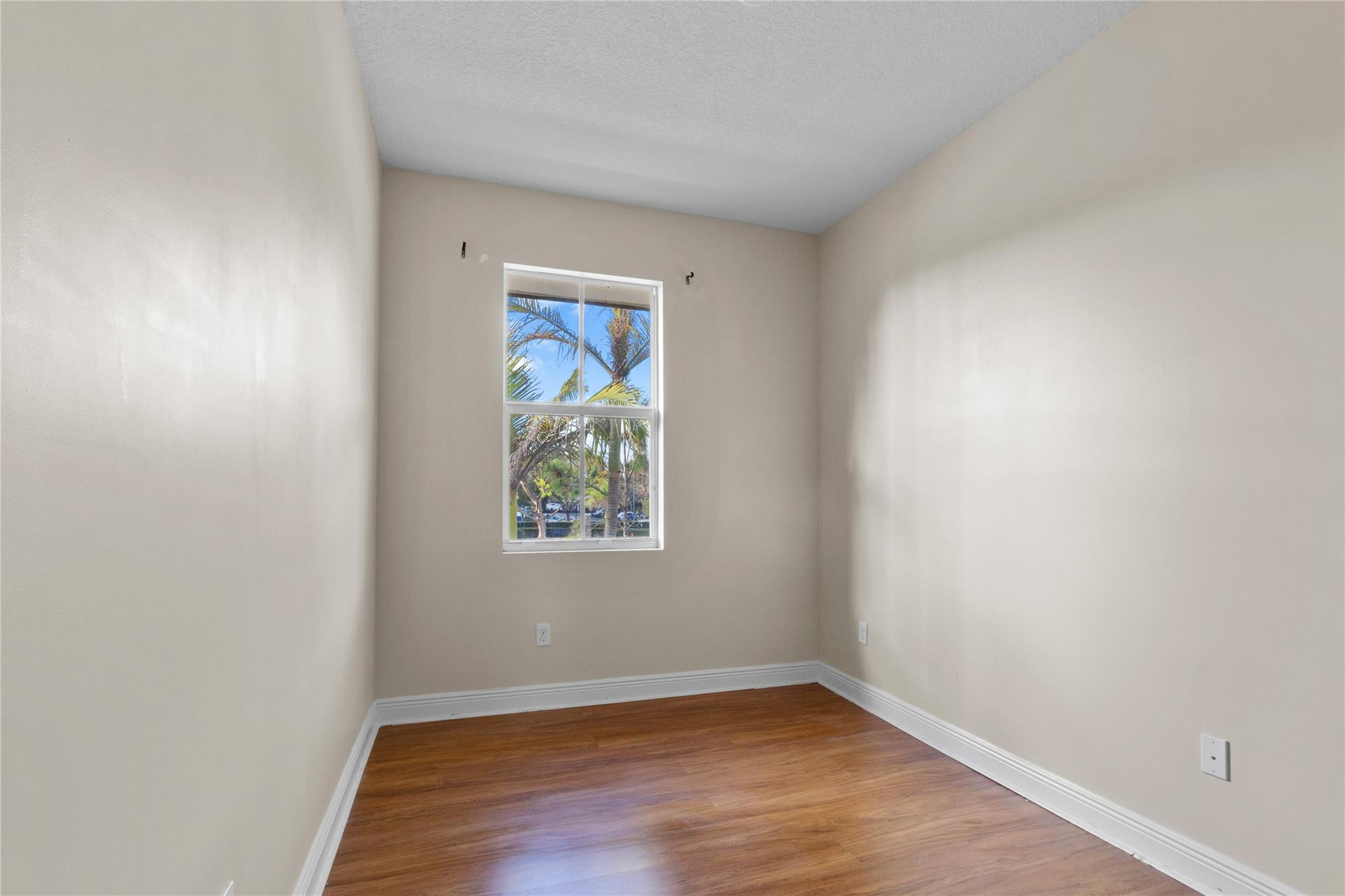 6918 Long Pine Circle Coconut Creek, FL 33073 - Photo 18 of 19 a view of an empty room with wooden floor and a window