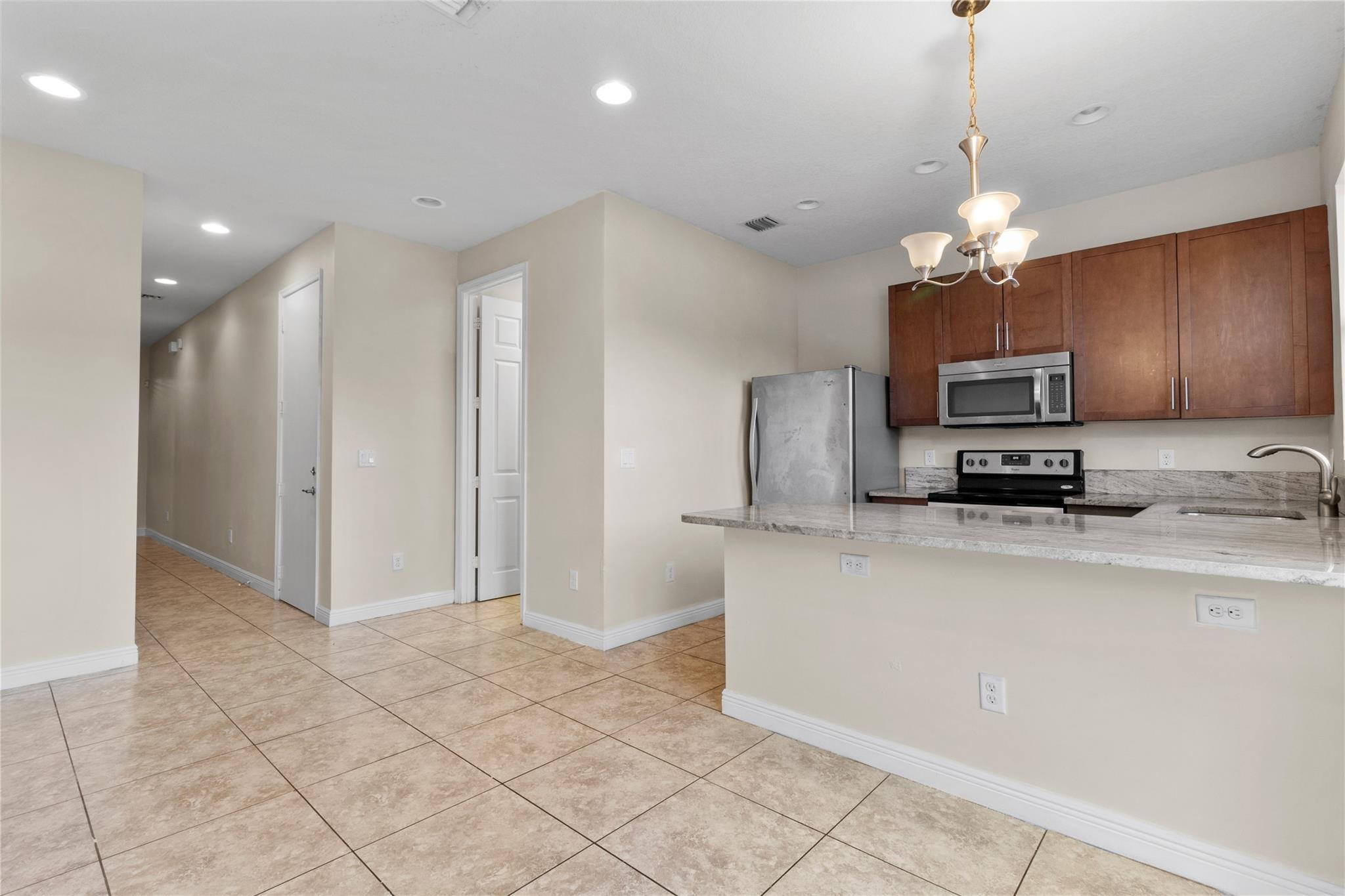 6918 Long Pine Circle Coconut Creek, FL 33073 - Photo 6 of 19 a kitchen with stainless steel appliances granite countertop a refrigerator a stove a sink and a microwave