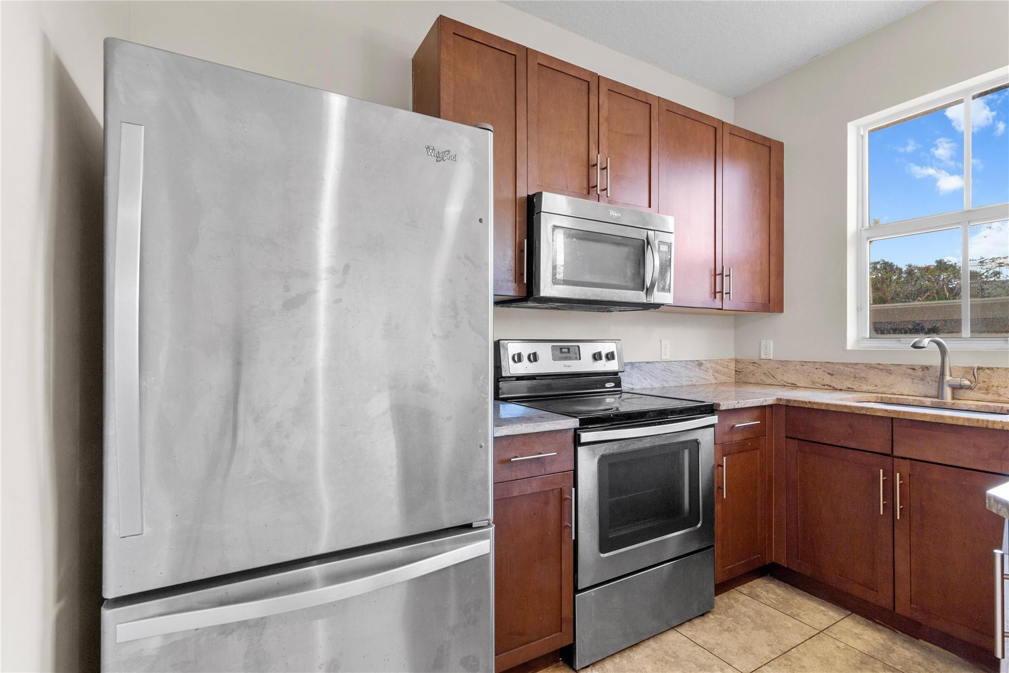 6918 Long Pine Circle Coconut Creek, FL 33073 - Photo 7 of 19 a kitchen with stainless steel appliances a refrigerator stove and microwave