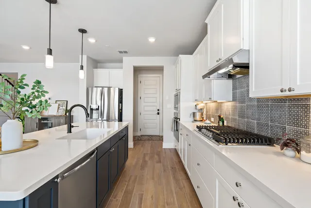 a kitchen with kitchen island a sink appliances cabinets and a counter top space