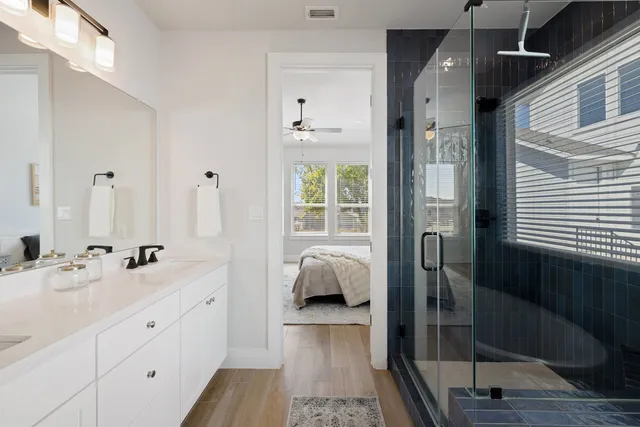 a en suite bathroom with a double vanity sink a mirror and shower