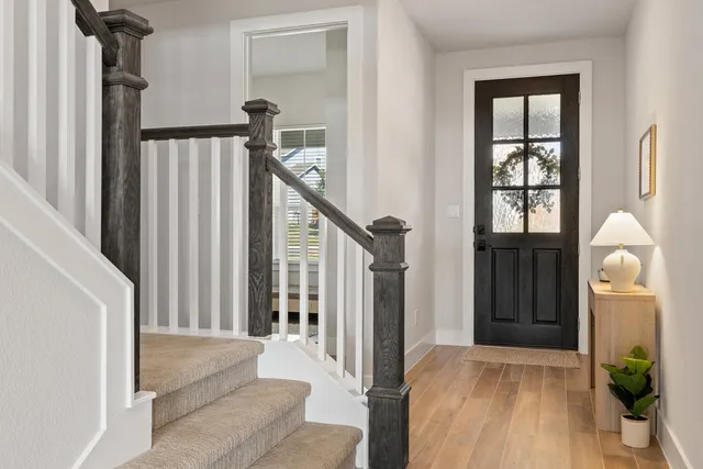 a view of a hallway with wooden floor and entryway