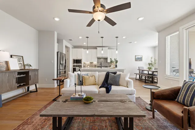 a living room with stainless steel appliances furniture and a dining table with kitchen view