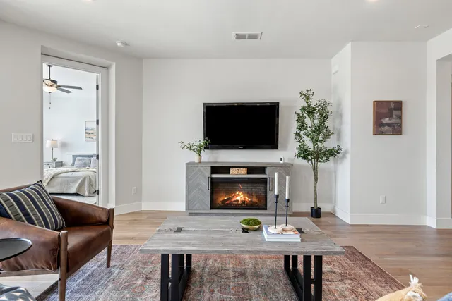 a living room with furniture a flat screen tv and a fireplace